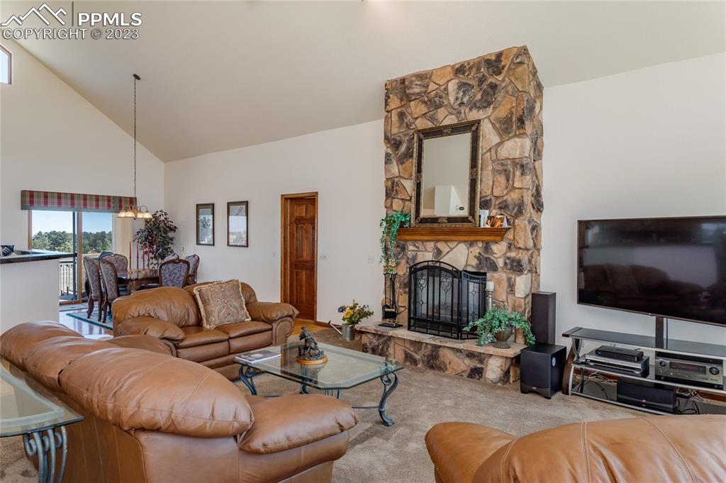 18165 Pinon Park Road Peyton, CO 80831 - Photo 6 of 44 a living room with furniture a flat screen tv and a fireplace