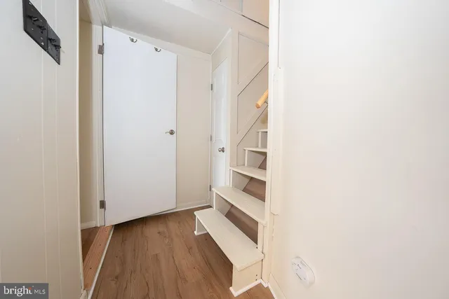 a view of a hallway with wooden floor and entryway
