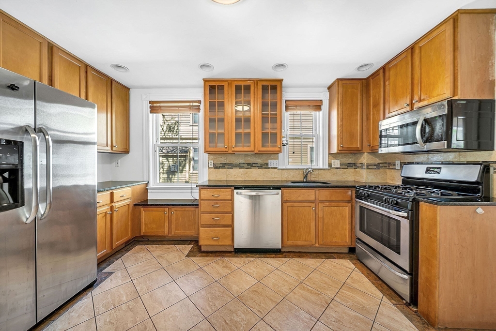 13 Weir Street Newton, MA 02466 - Photo 16 of 41 a kitchen with stainless steel appliances granite countertop a stove a sink and a microwave
