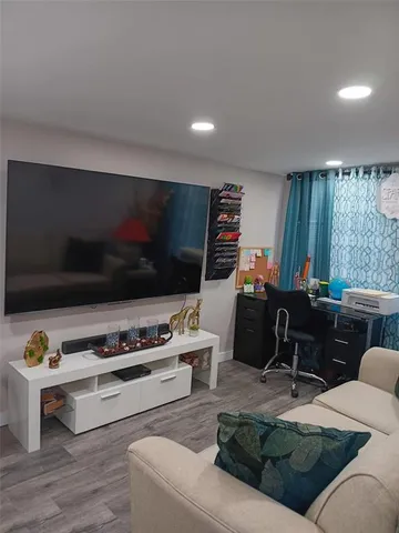 a living room with furniture flat screen tv and a window