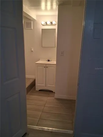 a view of a room with wooden floor and a ceiling fan