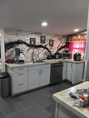 a kitchen with granite countertop a sink stainless steel appliances and cabinets