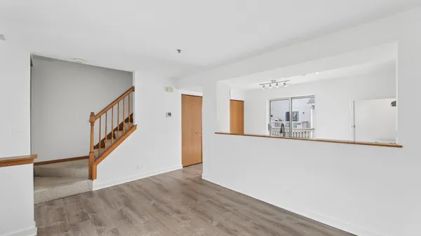 a view of a hallway with wooden floor and staircase