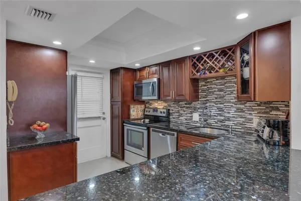 a kitchen with stainless steel appliances granite countertop a sink stove and refrigerator
