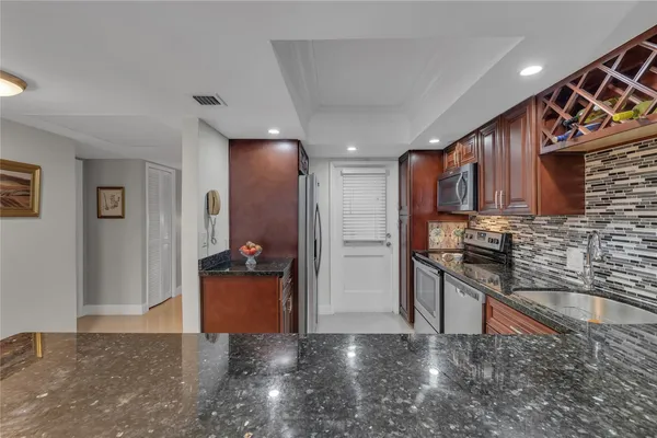 a kitchen with stainless steel appliances granite countertop a refrigerator and a sink