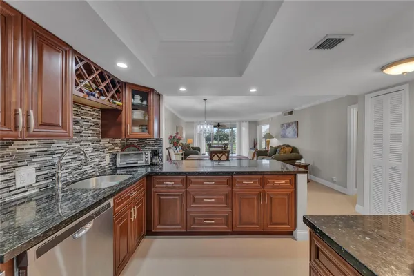 a kitchen with granite countertop a sink and cabinets