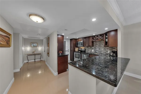 a view of a kitchen with refrigerator and chairs