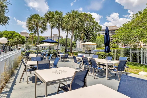 a view of a patio with a dining table and chairs with a fire pit