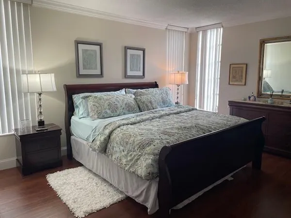 a bedroom with a bed lamps and on the dresser