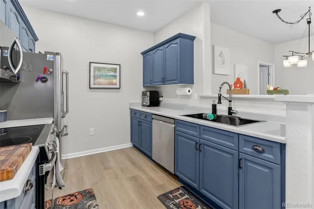 a kitchen with a sink refrigerator and cabinets