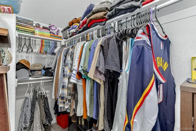 a view of walk in closet with clothes and shoes