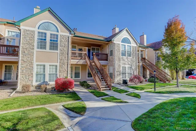 a front view of a house with a yard and potted plants