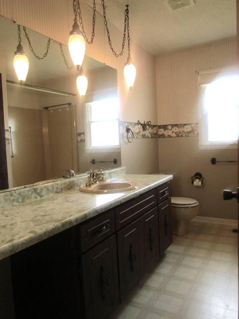 306 College Boulevard Carmi, IL 62821 - Photo 14 of 23 a bathroom with a granite countertop sink a toilet and mirror