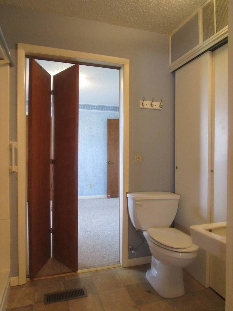 306 College Boulevard Carmi, IL 62821 - Photo 19 of 23 a white toilet sitting next to a bathroom sink