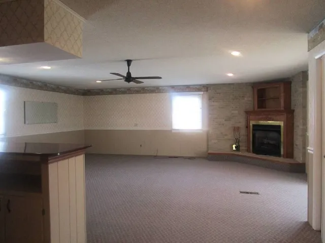 an empty room with windows and fireplace
