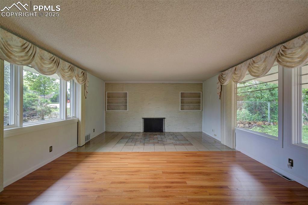 130 Cresta Road Colorado Springs, CO 80906 - Photo 11 of 49 an empty room with wooden floor and windows