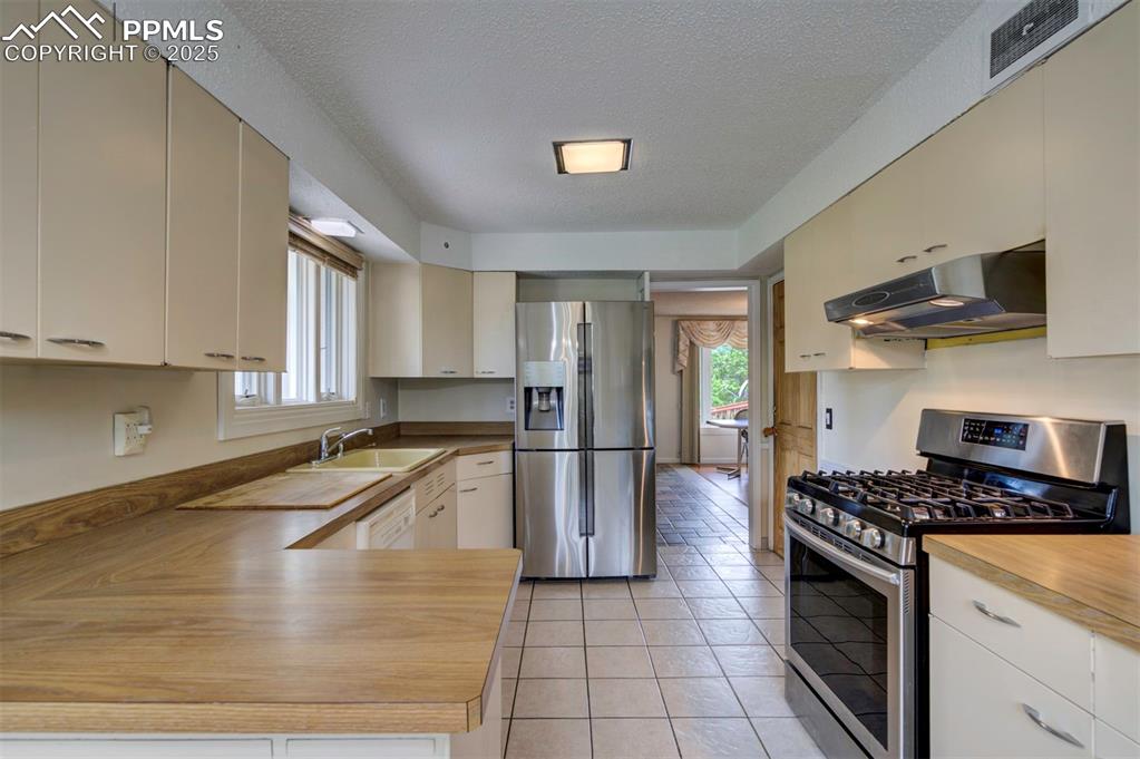 130 Cresta Road Colorado Springs, CO 80906 - Photo 13 of 49 a kitchen with granite countertop a stove a sink and a refrigerator
