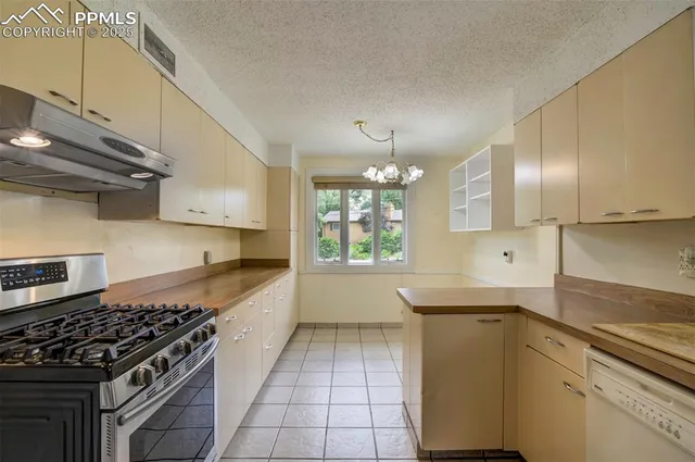 a kitchen with stainless steel appliances granite countertop a sink a stove and a wooden floors