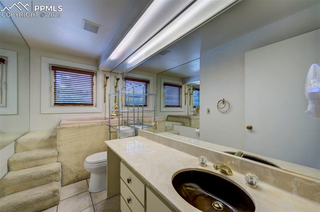 130 Cresta Road Colorado Springs, CO 80906 - Photo 22 of 49 a bathroom with a sink a toilet and mirror
