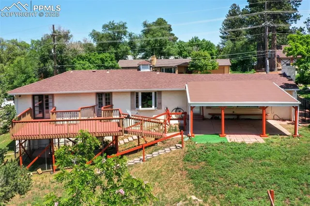 an aerial view of a house with swimming pool and garden