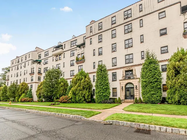 a view of a building with a yard and plants