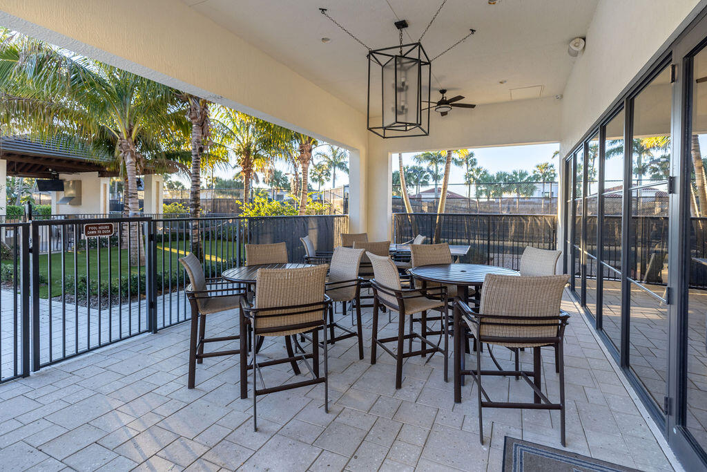 2740 Northwest 69th Street Boca Raton, FL 33496 - Photo 71 of 79 a dining room with furniture a chandelier and flat screen tv