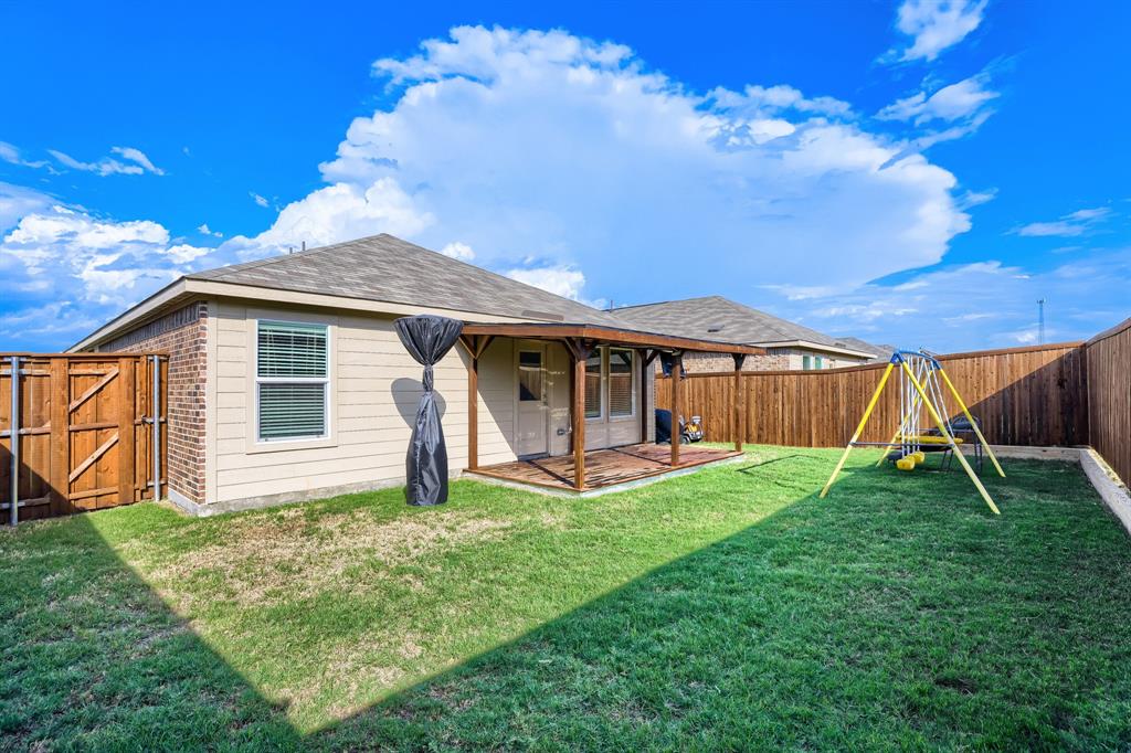 1619 Grassy Pond Road Forney, TX 75126 - Photo 28 of 28 Expansive fenced backyard featuring a covered patio with wood-finish decking and a wooden privacy fence