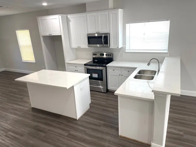 a kitchen with a stove a sink and a refrigerator