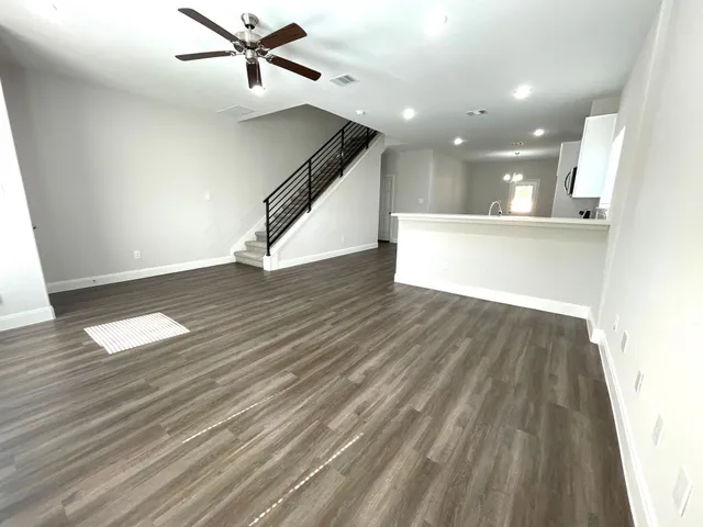 a view of a room with wooden floor and ceiling fan