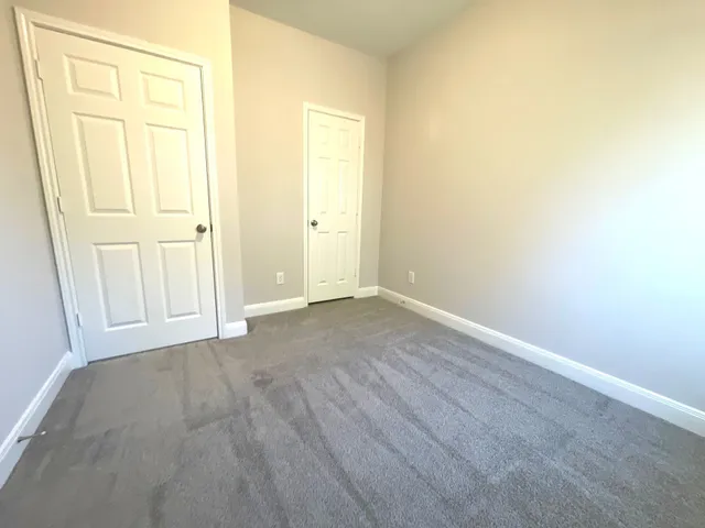 an empty room with wooden floor and closet area