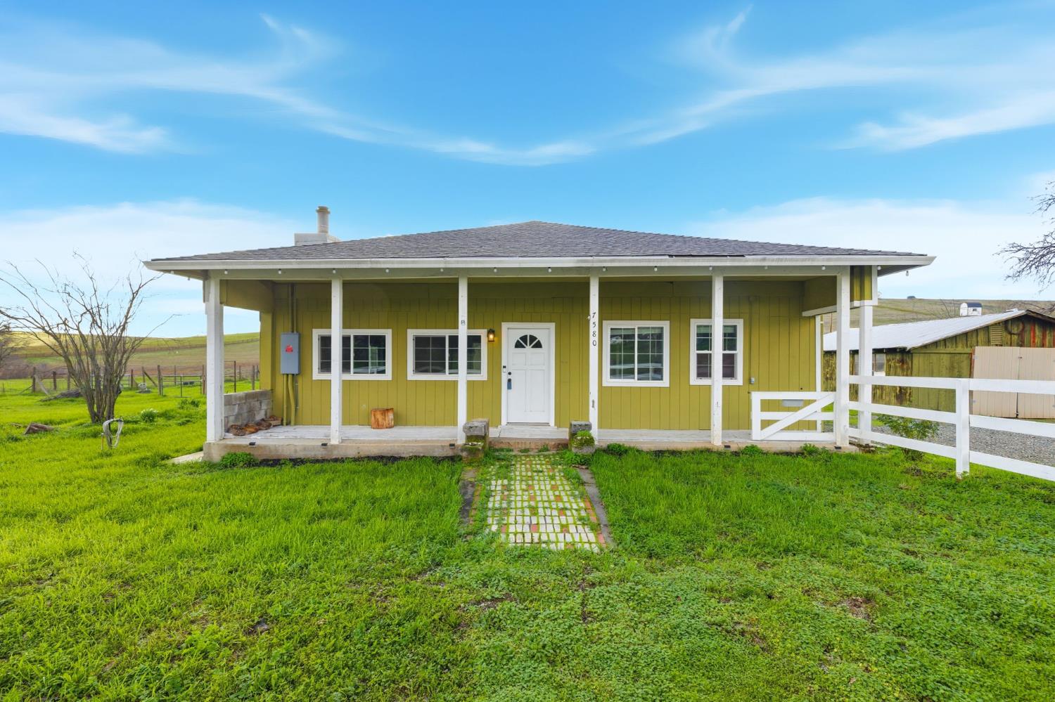 a view of an house with backyard space and balcony