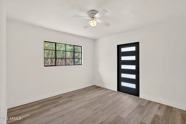 an empty room with a window and wooden floor