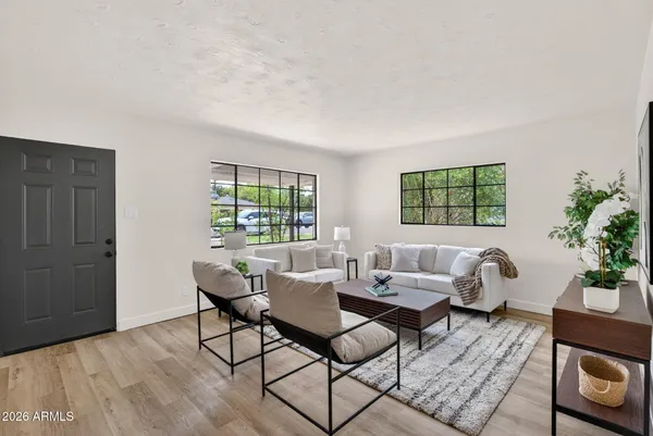 a living room with furniture a window and a potted plant