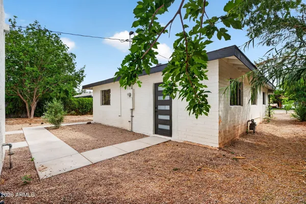 a front view of a building with a garden and plants