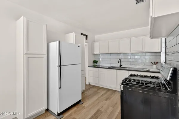 a kitchen with granite countertop a stove sink and cabinets