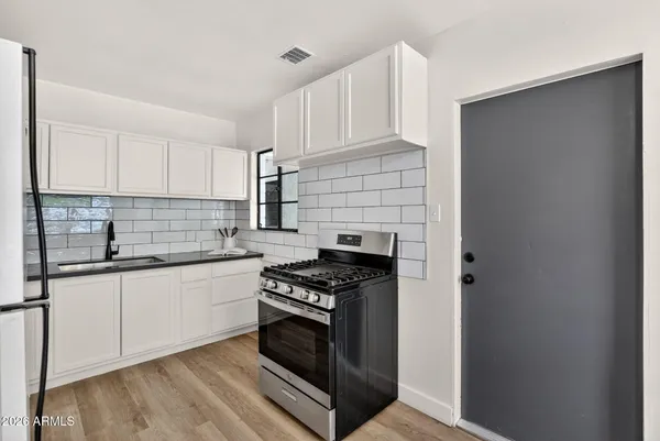 a kitchen with granite countertop white cabinets and a sink