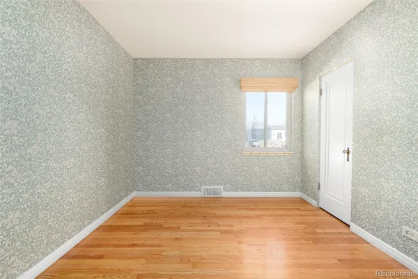 a view of empty room with wooden floor