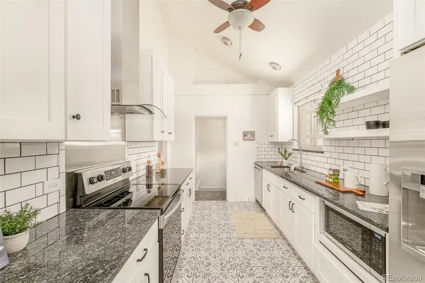 a kitchen with stainless steel appliances granite countertop a sink and a stove