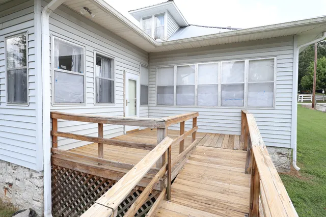 a view of a balcony with wooden floor and iron stairs