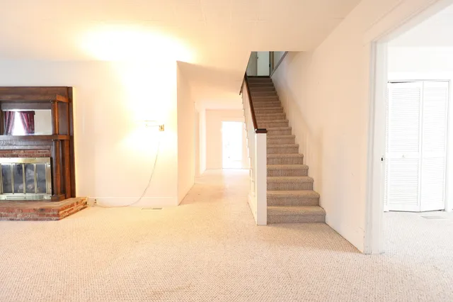 a view of a livingroom with wooden floor and a fireplace
