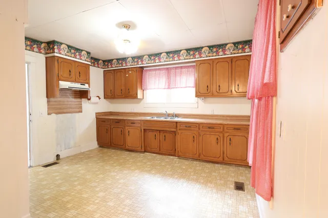 a kitchen with granite countertop a sink and cabinets