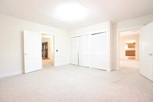 a view of an empty room with window and a bathroom