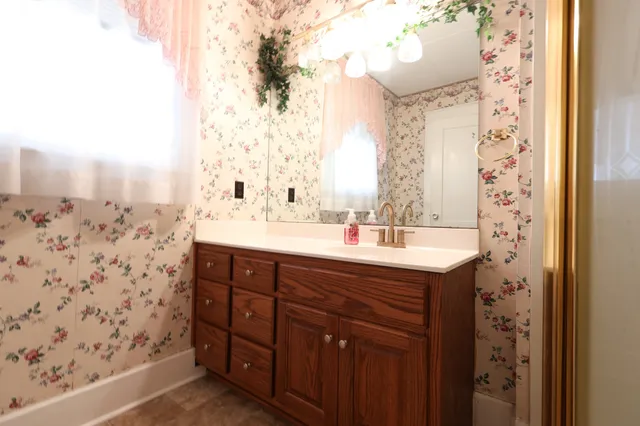 a bathroom with a granite countertop sink and a mirror