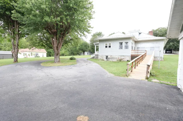 a view of a house with backyard and a tree