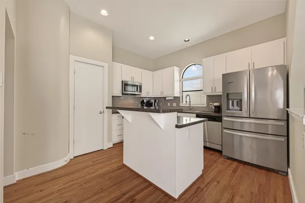a kitchen with stainless steel appliances granite countertop a refrigerator sink and stove