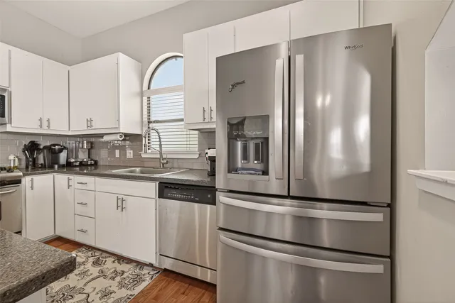 a kitchen with granite countertop stainless steel appliances and white cabinets