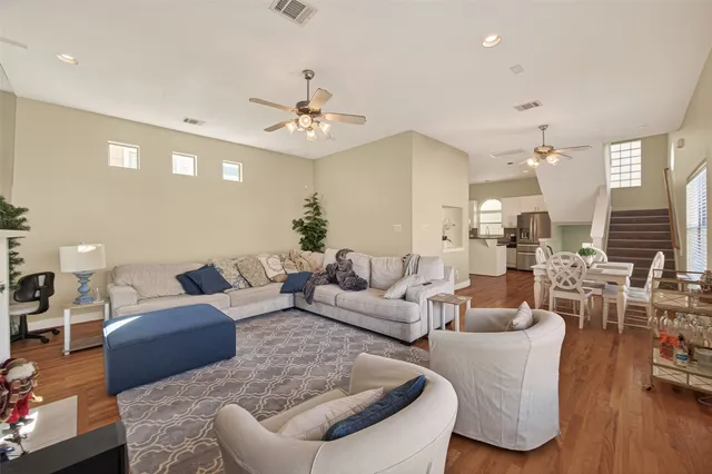 a living room with furniture kitchen view and a chandelier