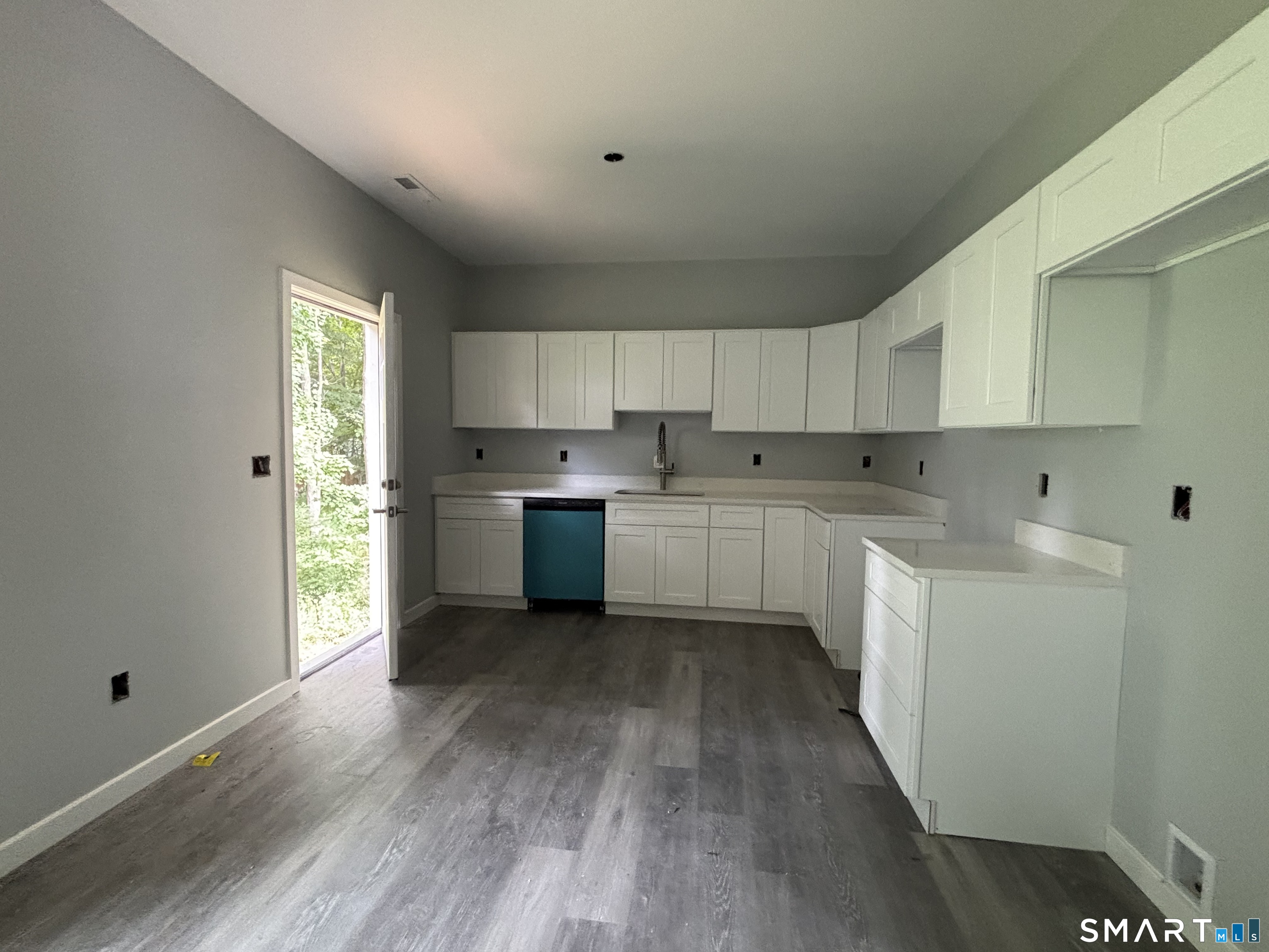 9 Putnam Park Road Bethel, CT 06801 - Photo 11 of 16 a kitchen with wooden floors and white cabinets