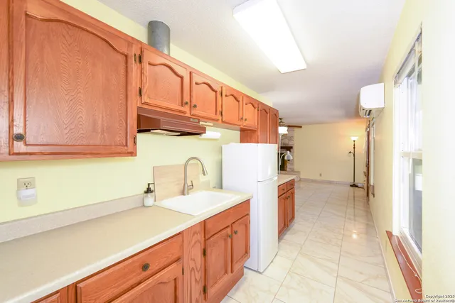 a kitchen with a sink cabinets and a refrigerator
