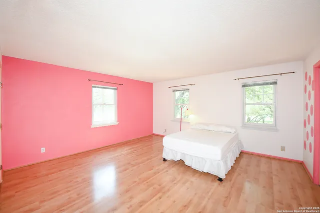 a spacious bedroom with a bed and a window